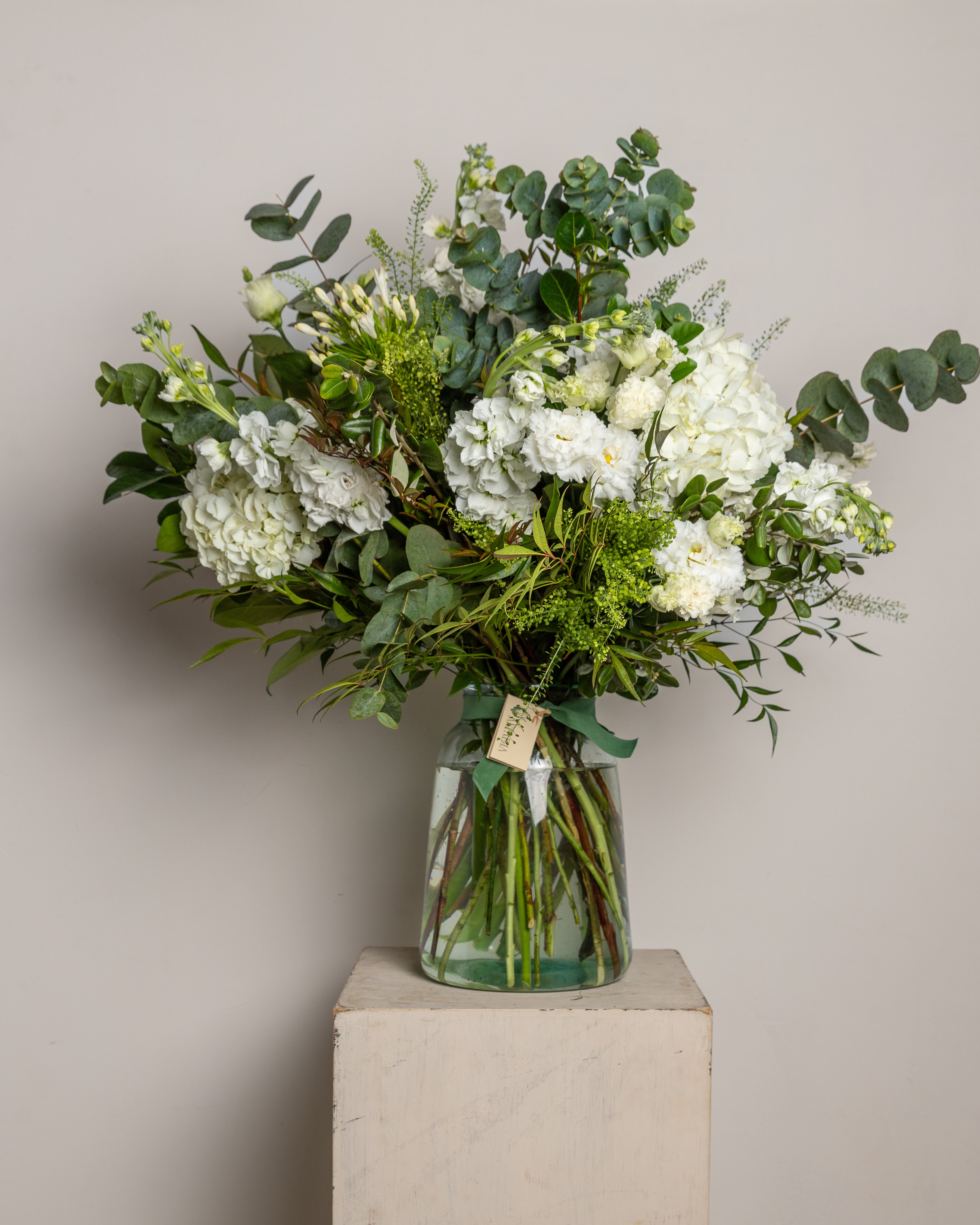Jarrón de cristal con flores blancas