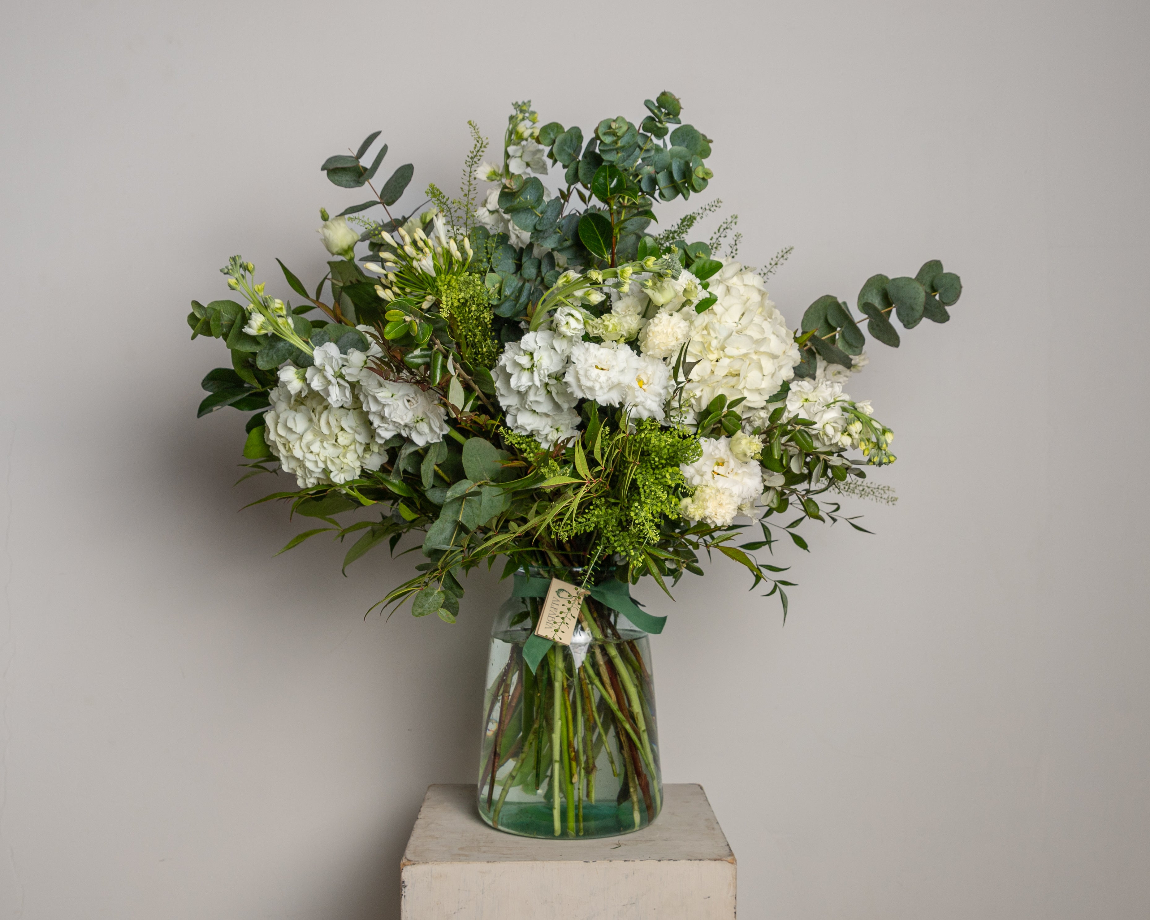 Jarrón de cristal con flores blancas